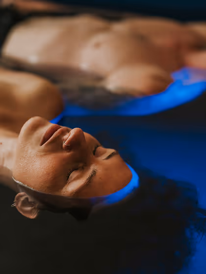 Couple doing float therapy eyes closed blue water