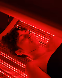 Women with eyes closed using red light therapy