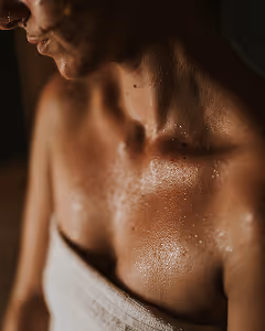 Women in infrared sauna sweating in towel