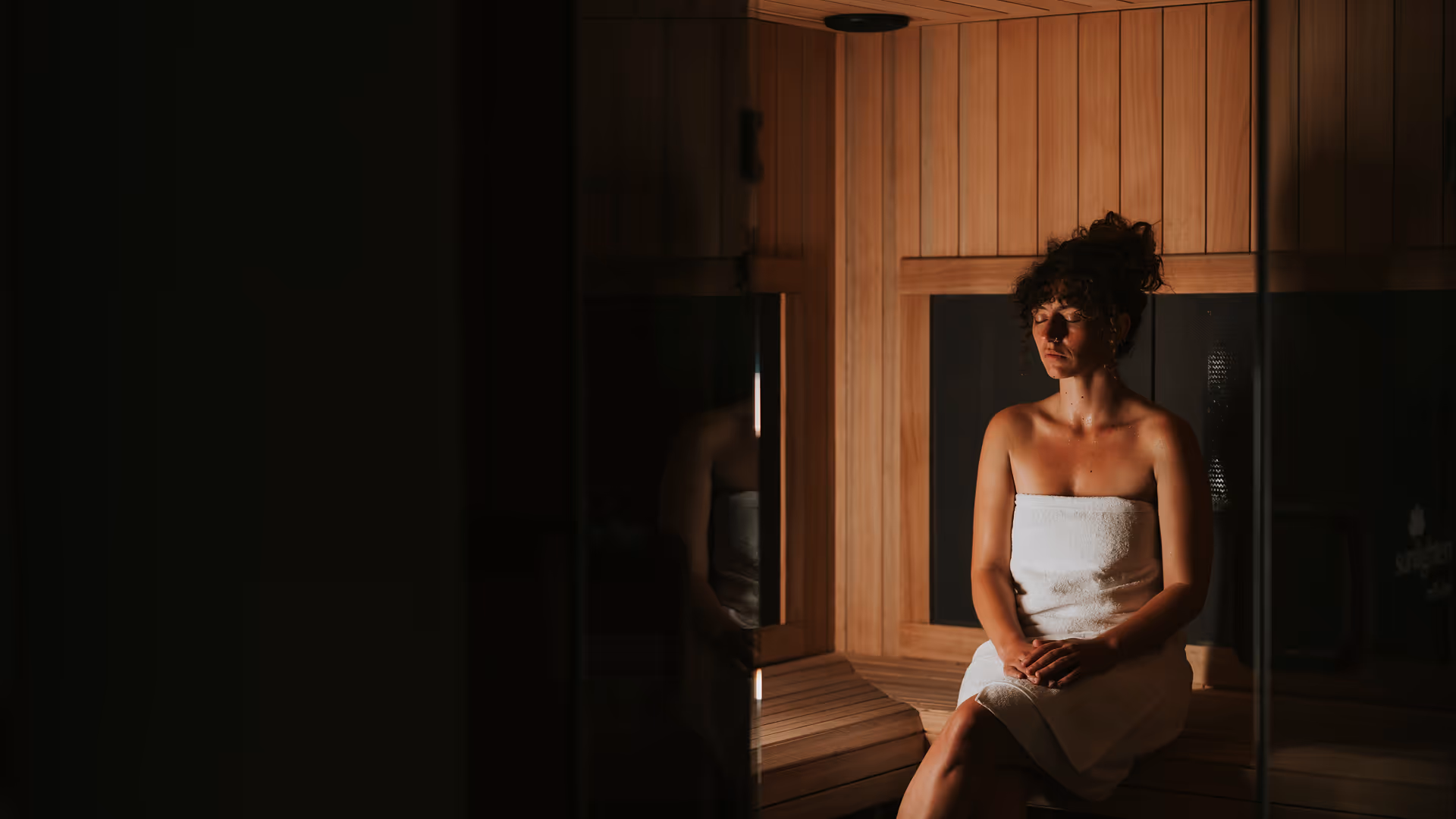 Women sitting in infrared sauna eyes-closed deep focus