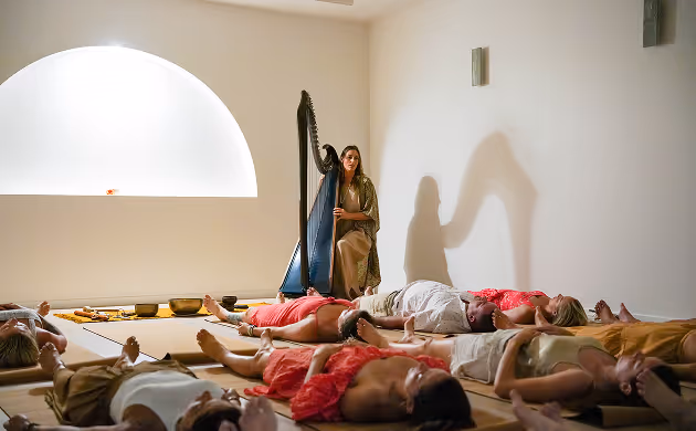 women plays harp for relaxing people