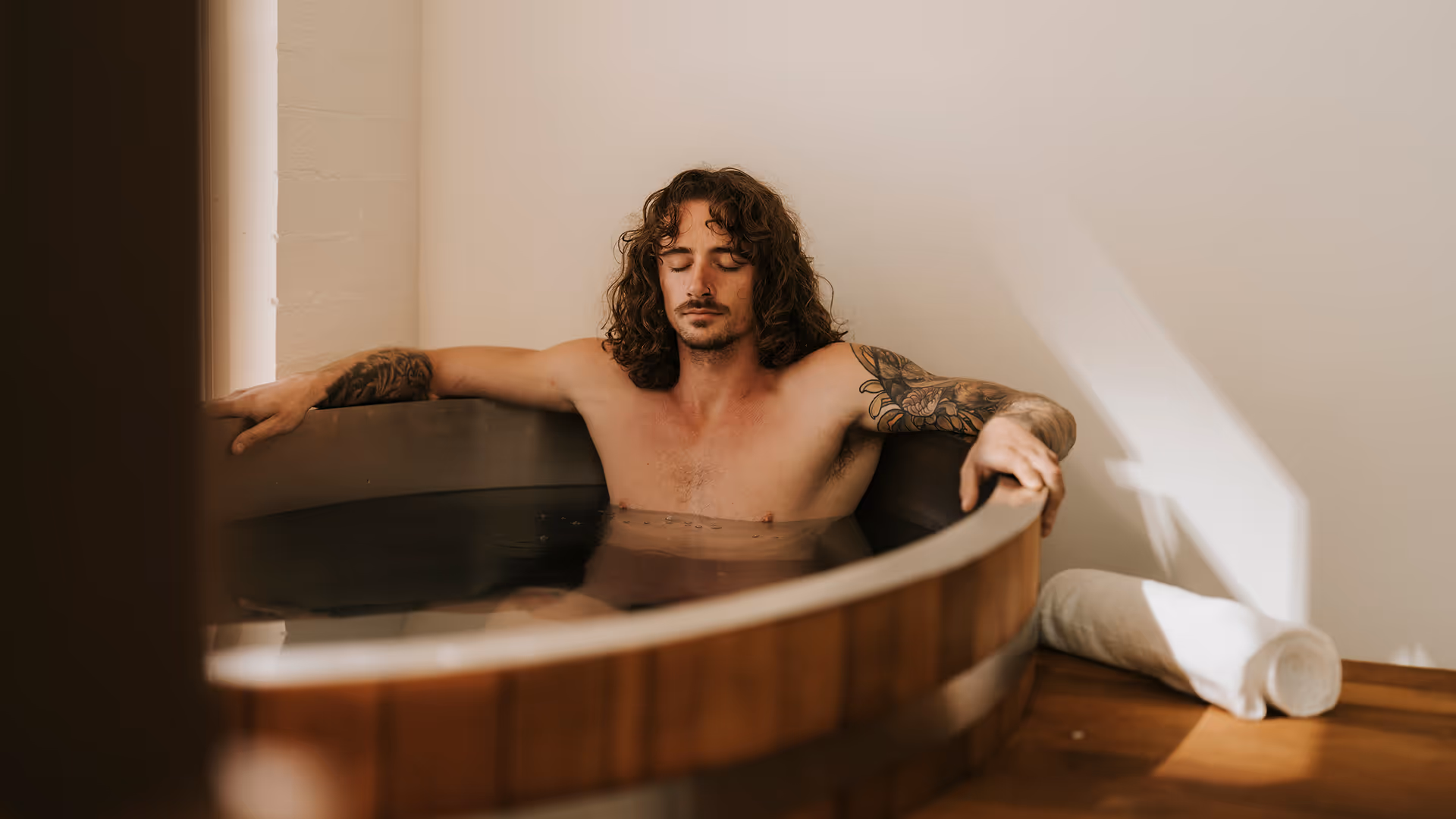 man sitting in ice bath with eyes closed