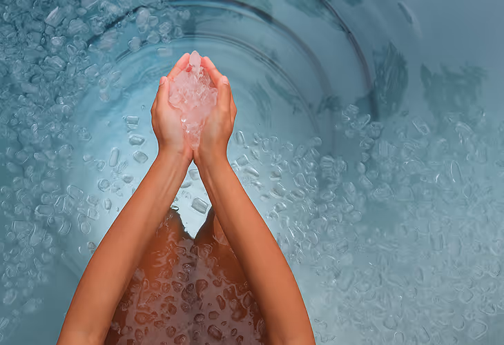 women holding ice in water