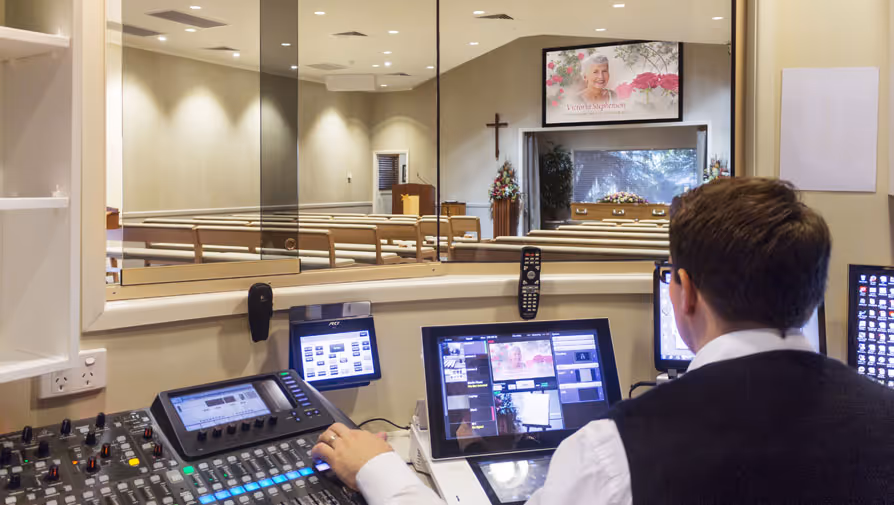 A technician controls funeral service media.