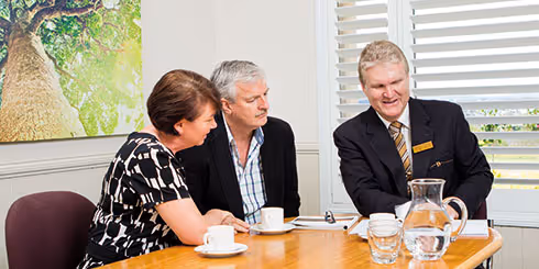 A funeral director consults with a couple about funeral arrangements.
