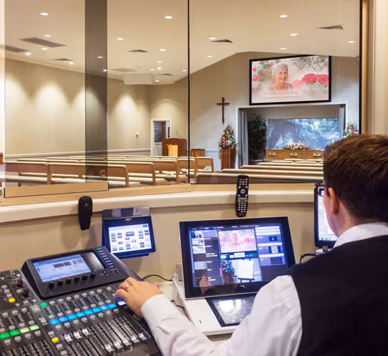 A technician at a soundboard in a church.