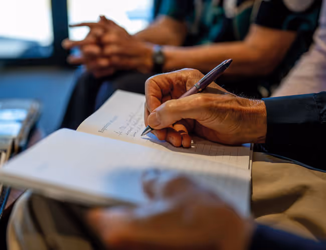 Close-up of a person's hand writing in a notebook.