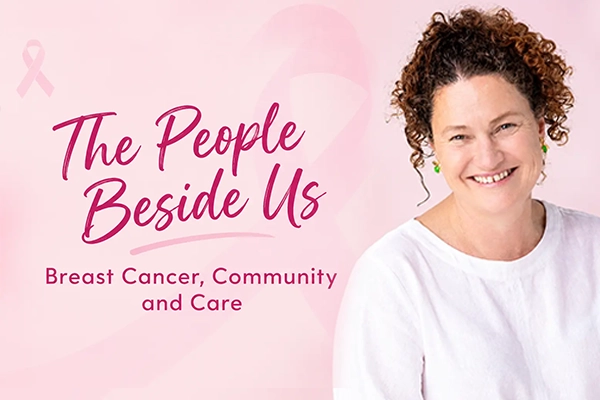 A graphic featuring a smiling woman with curly hair alongside pink cursive text reading "The People Beside Us" and "Breast Cancer, Community and Care" against a light pink background with a subtle ribbon watermark.