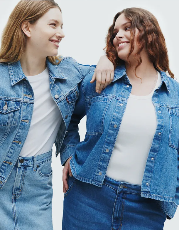 Two women standing next to each other wearing denim