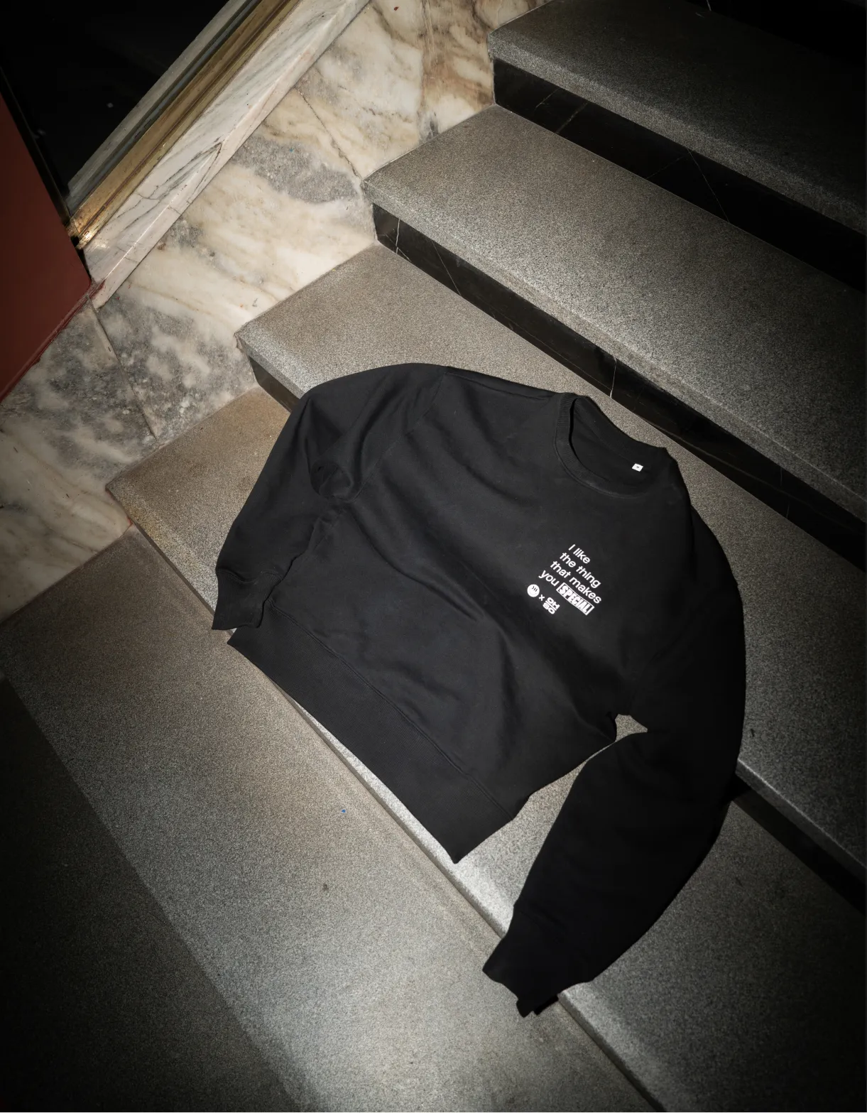 OH-SO black sweater photographed on the stairs.