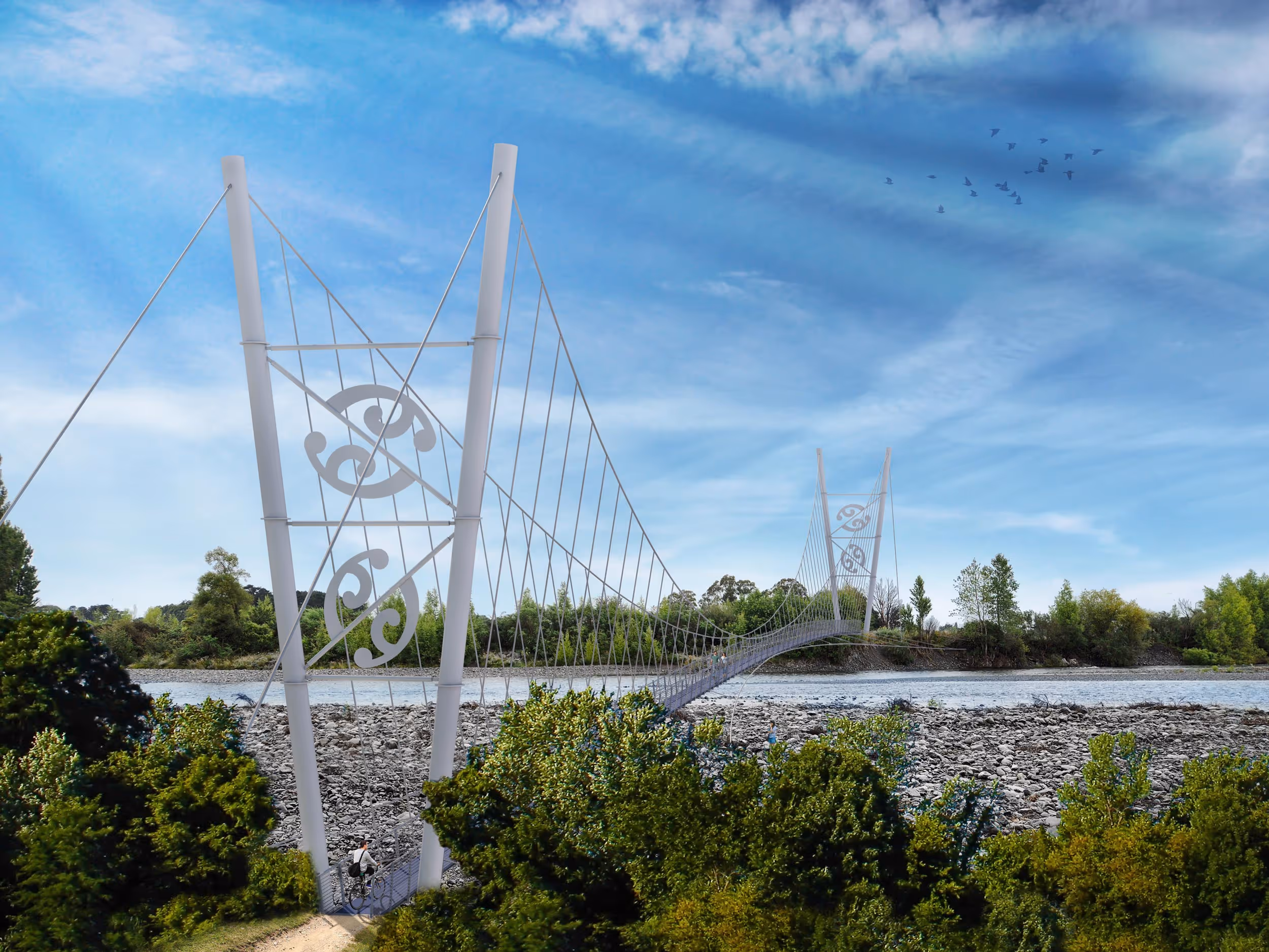 Suspension bridge with artistic side panels spanning the Waiohine River, surrounded by green trees under a blue sky with scattered clouds and flying birds.