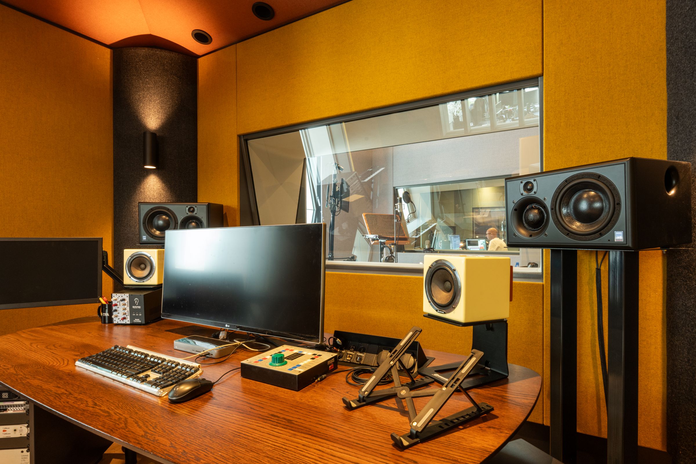 Werkplek in studio 3 van TFA met scherm, controller en studiomonitoren voor het opnameraam