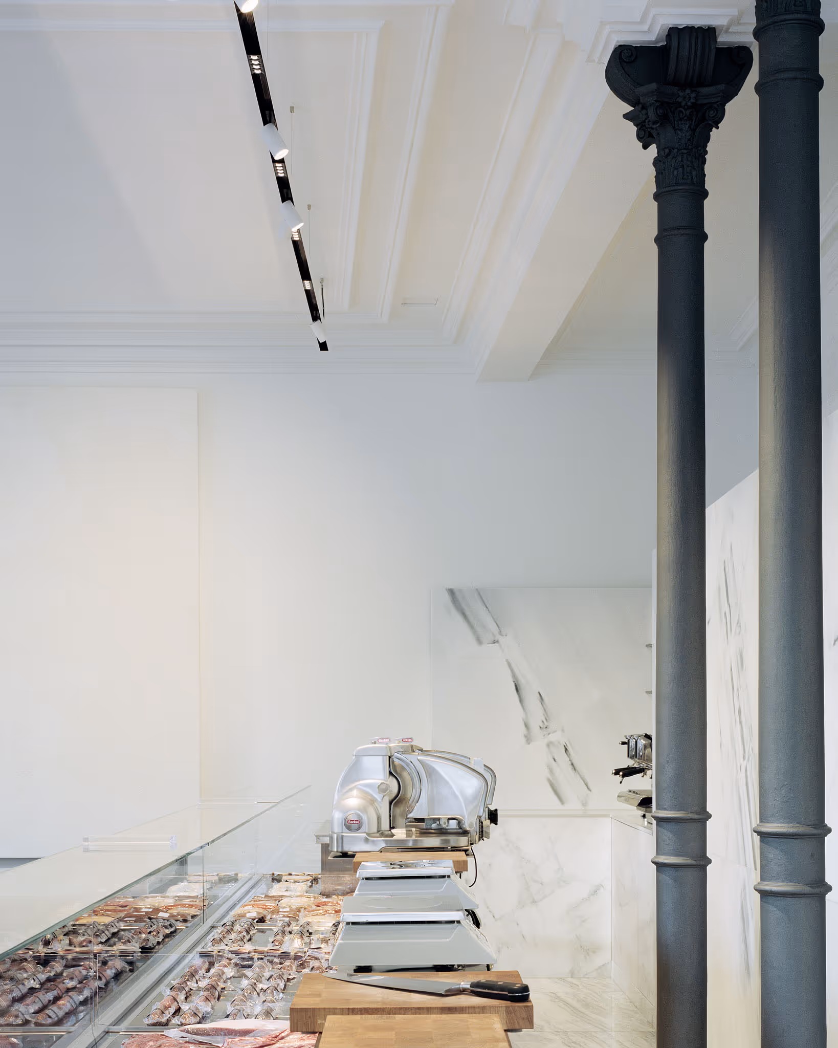 Elegante Metzgerei mit Fleischtheke, Schneidemaschine und klassischer Säule