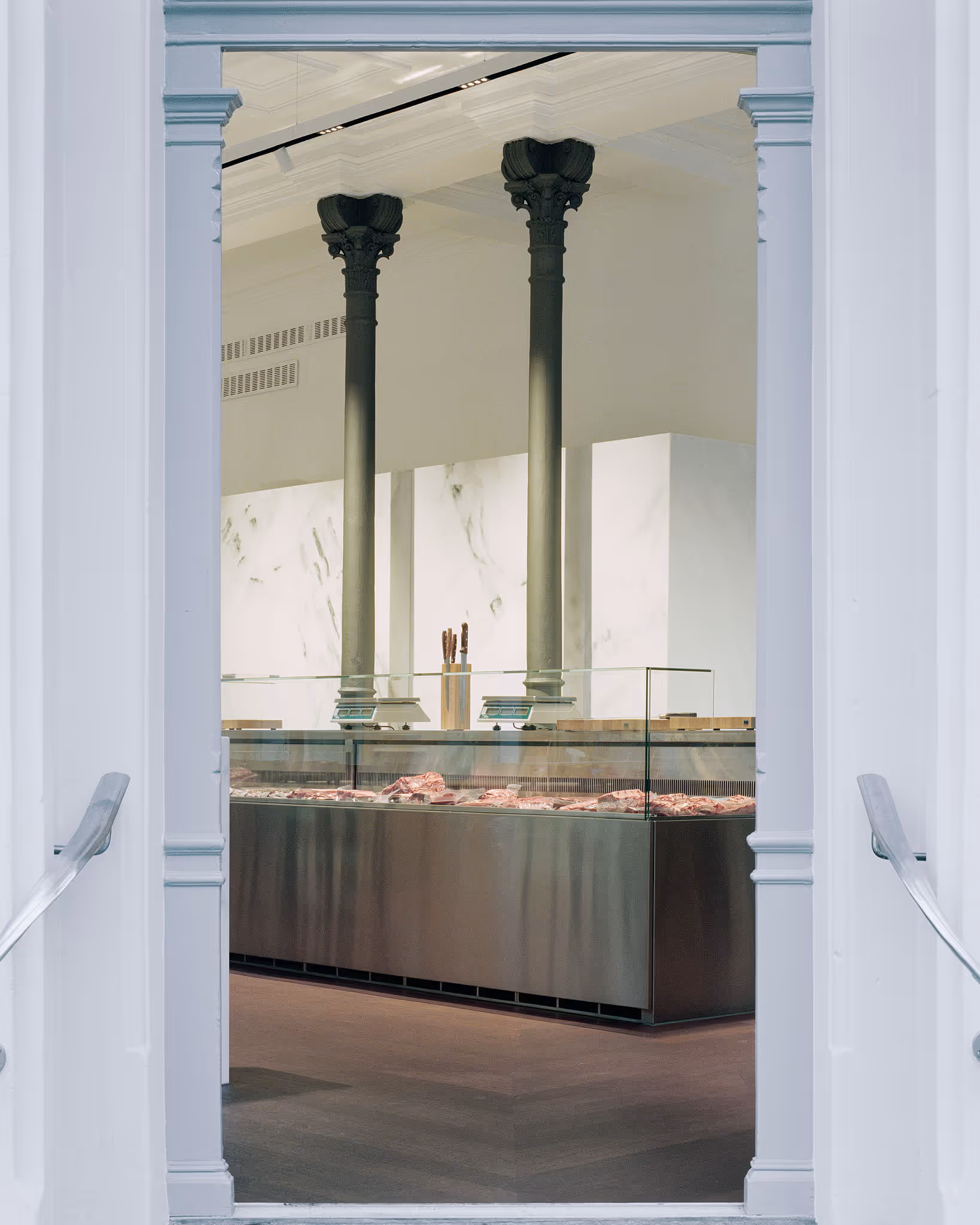 Fleischtheke mit klassischen Säulen in elegantem, minimalistischem Interieur