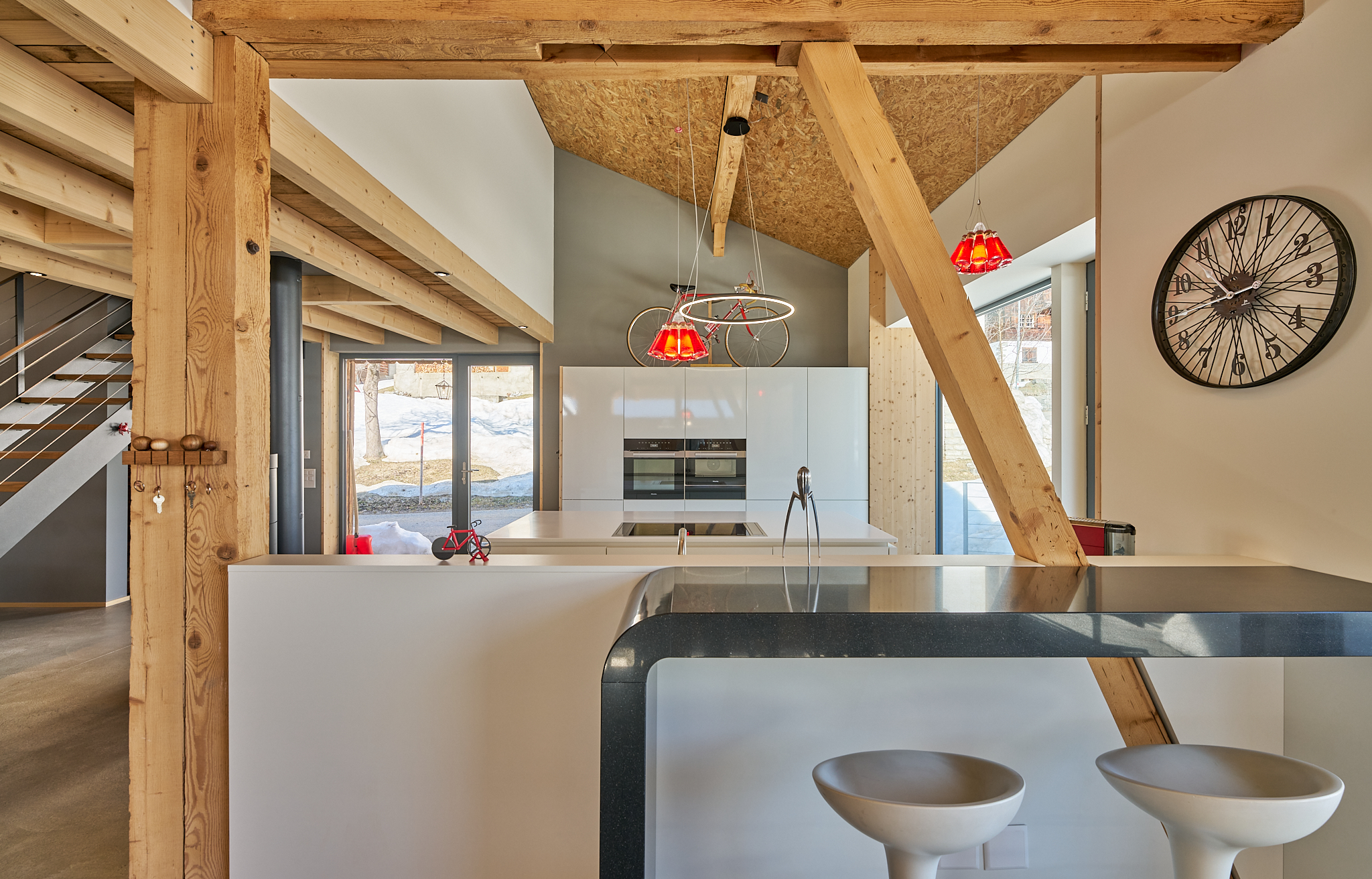 Moderne Küche mit Holzbalken, Fahrradlampe und großer Fensterfront