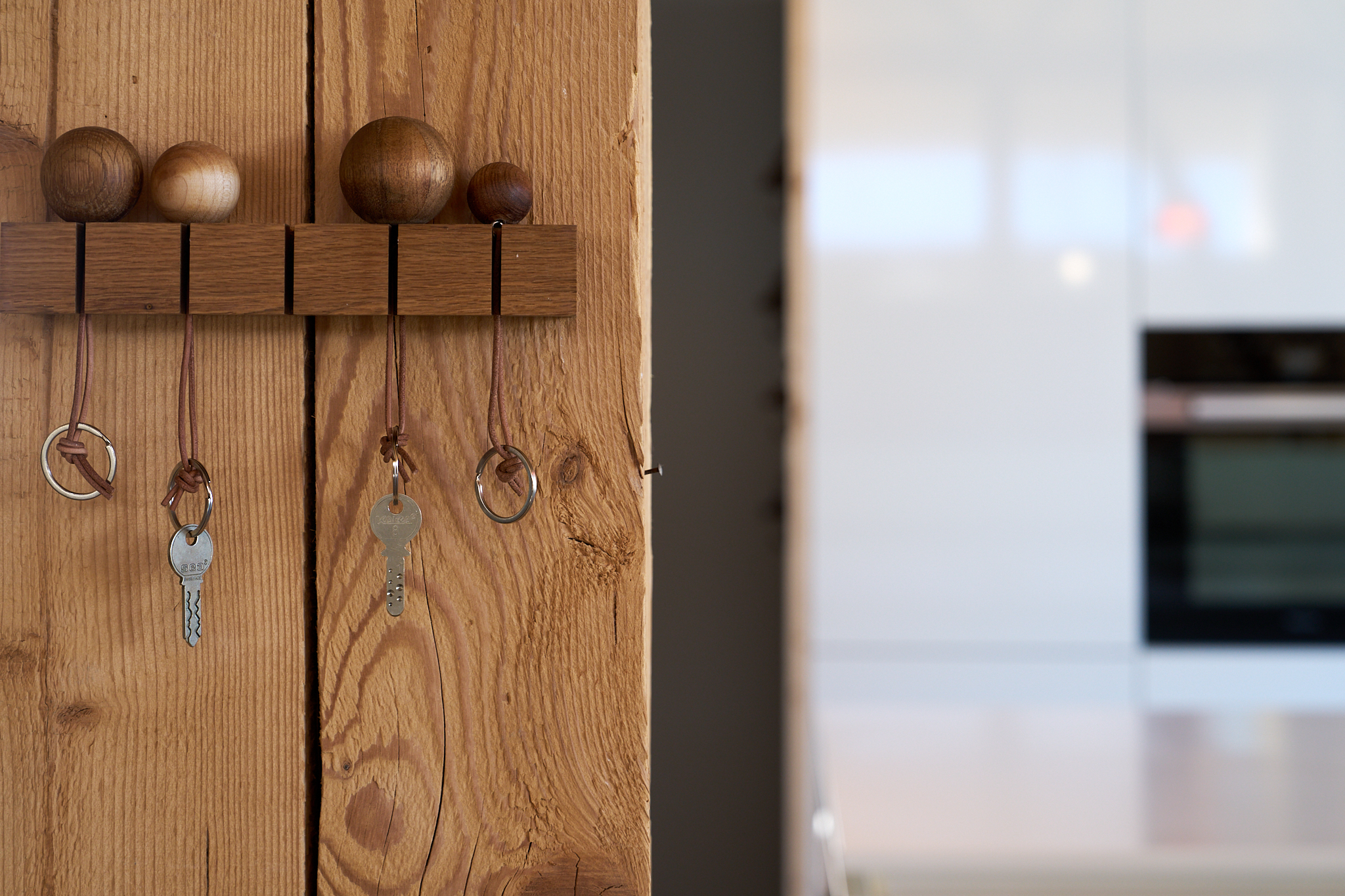 Holzwand mit Schlüsselhaken und Holzkugeln in minimalistischem Design