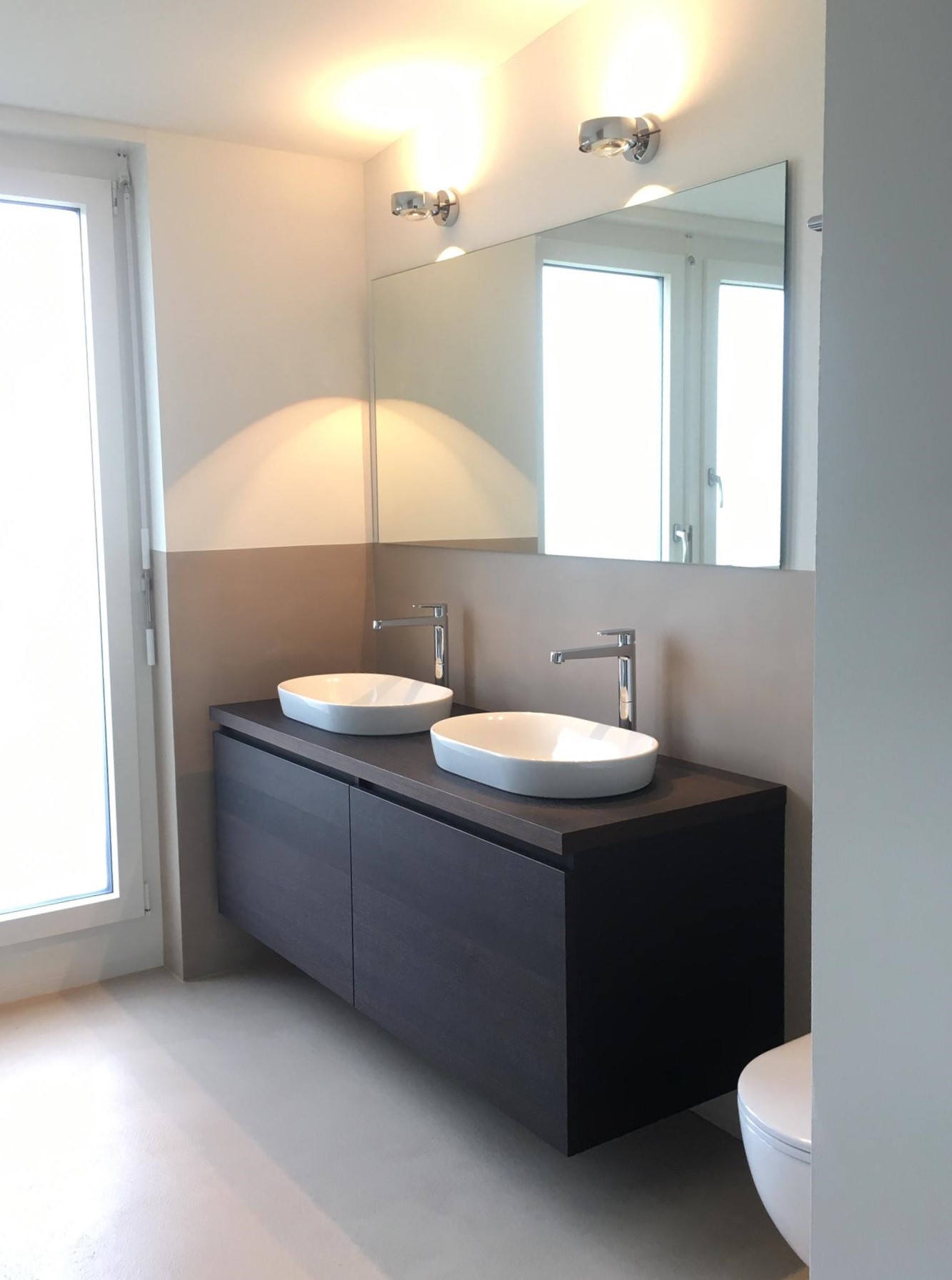 Modernes Badezimmer mit zwei Waschbecken, Spiegel und warmem Licht