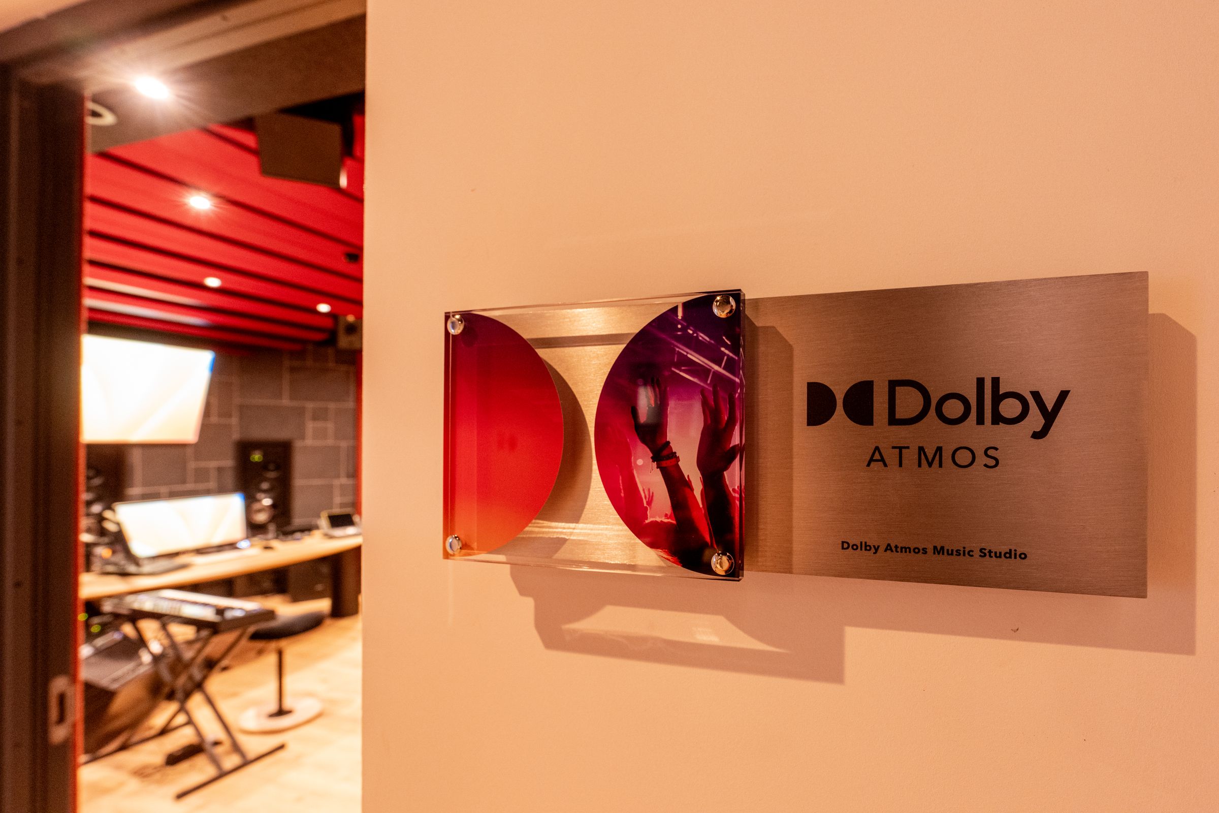 Bord met Dolby Atmos-logo naast de rode studio van TFA