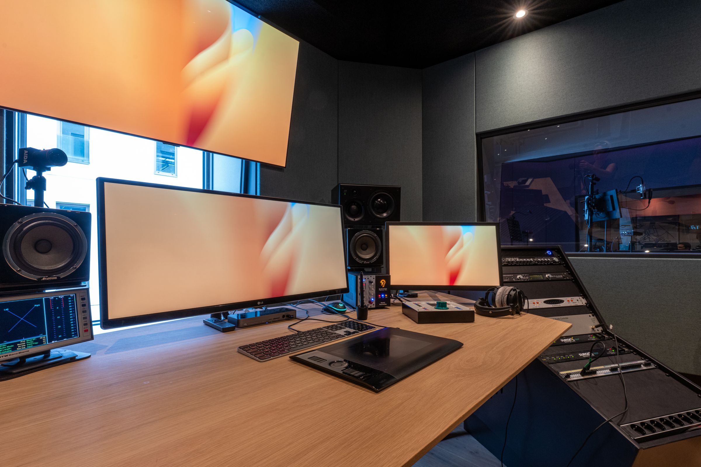 Werkplek in een TFA-studio met twee grote schermen, toetsenbord en studiomonitoren