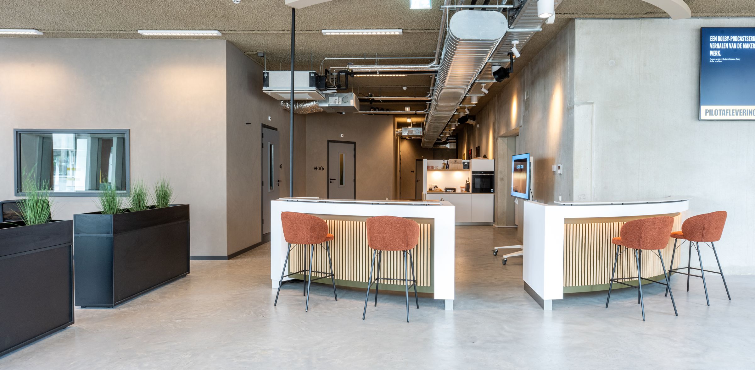 Lichte lounge van TFA aan de Houthavens met een bar, barkrukken en planten