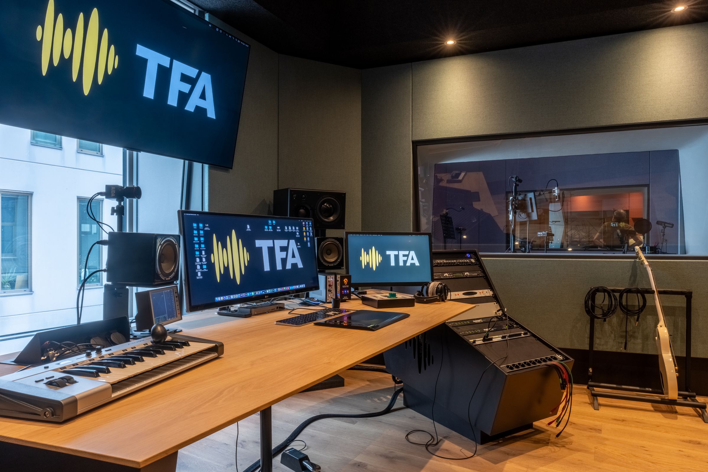 Regietafel in een TFA-studio met keyboard, schermen met het TFA-logo en studiomonitoren