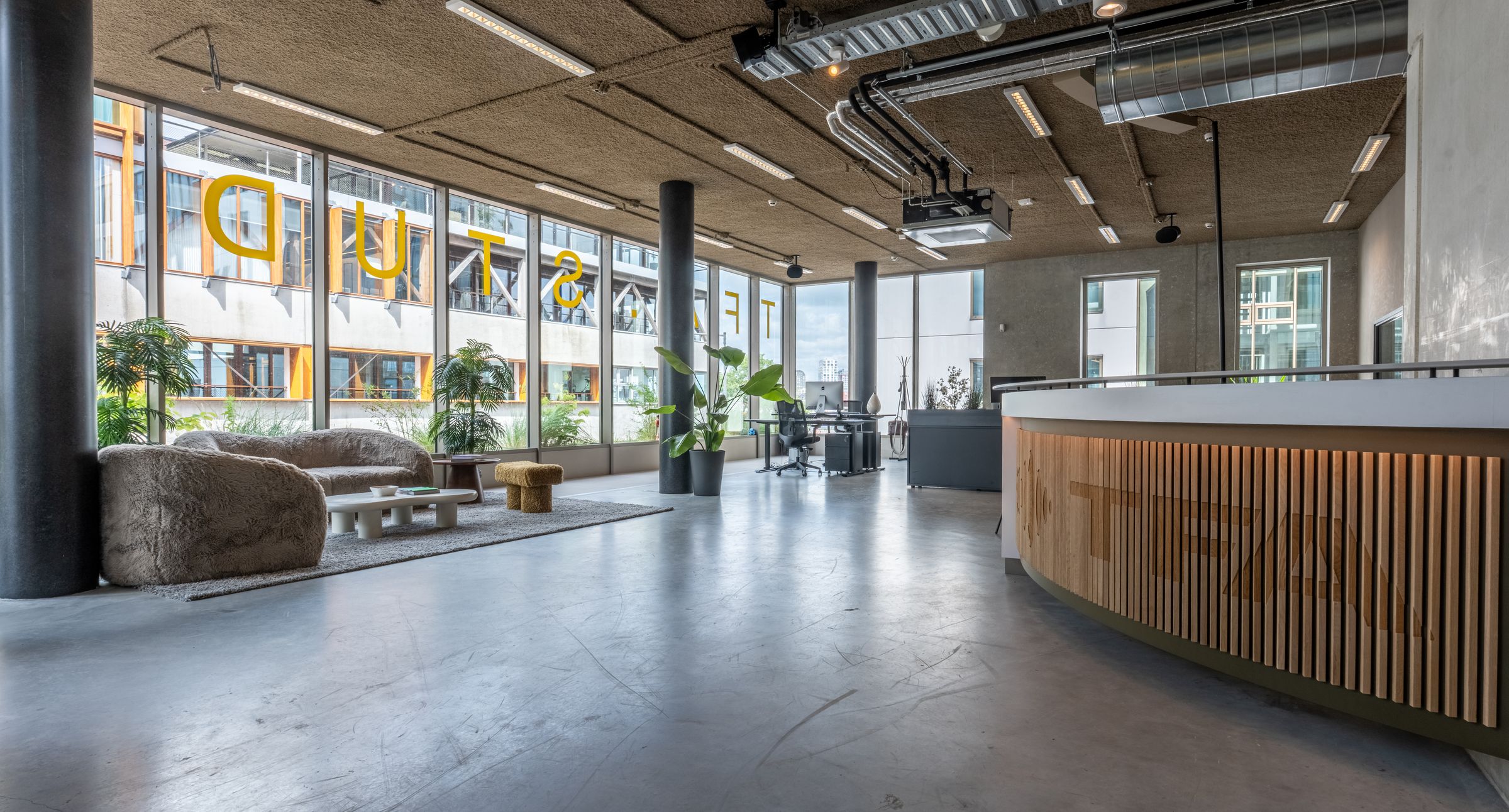 Lichte lounge van TFA aan de Houthavens met een bar, barkrukken en planten