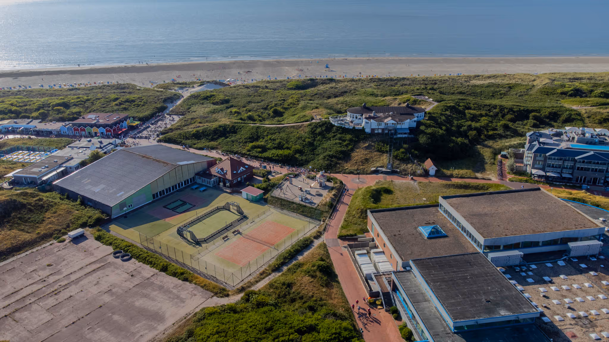 Luftansicht der Insel Langeoog mit Tennisplätzen, Sportplatz, Dünen und Strand