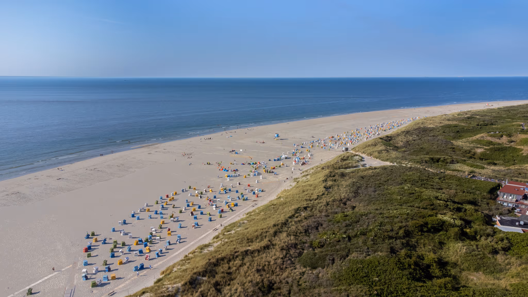Panoramablick auf den Strand von Langeoog mit Strandkörben am Meer