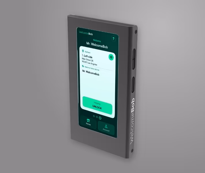 En moderne smart enhed på væg med display, der viser velkomstskærm til Mr. WelcomeBob og en grøn oplåsningsknap.