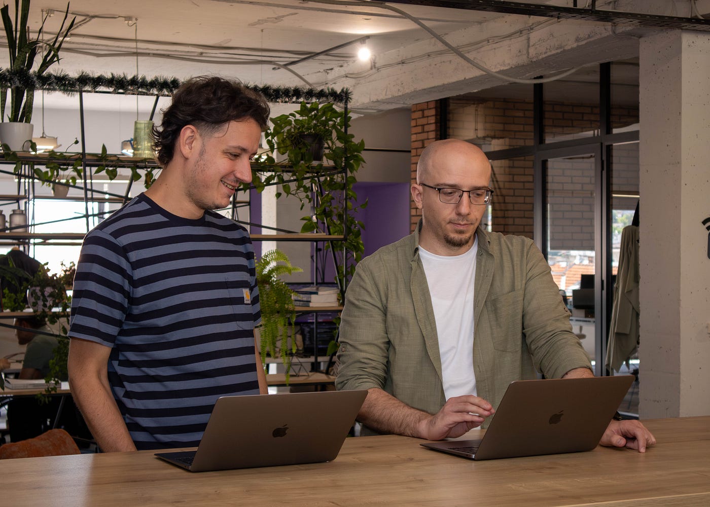 Two colleagues collaborating on a laptop in the office
