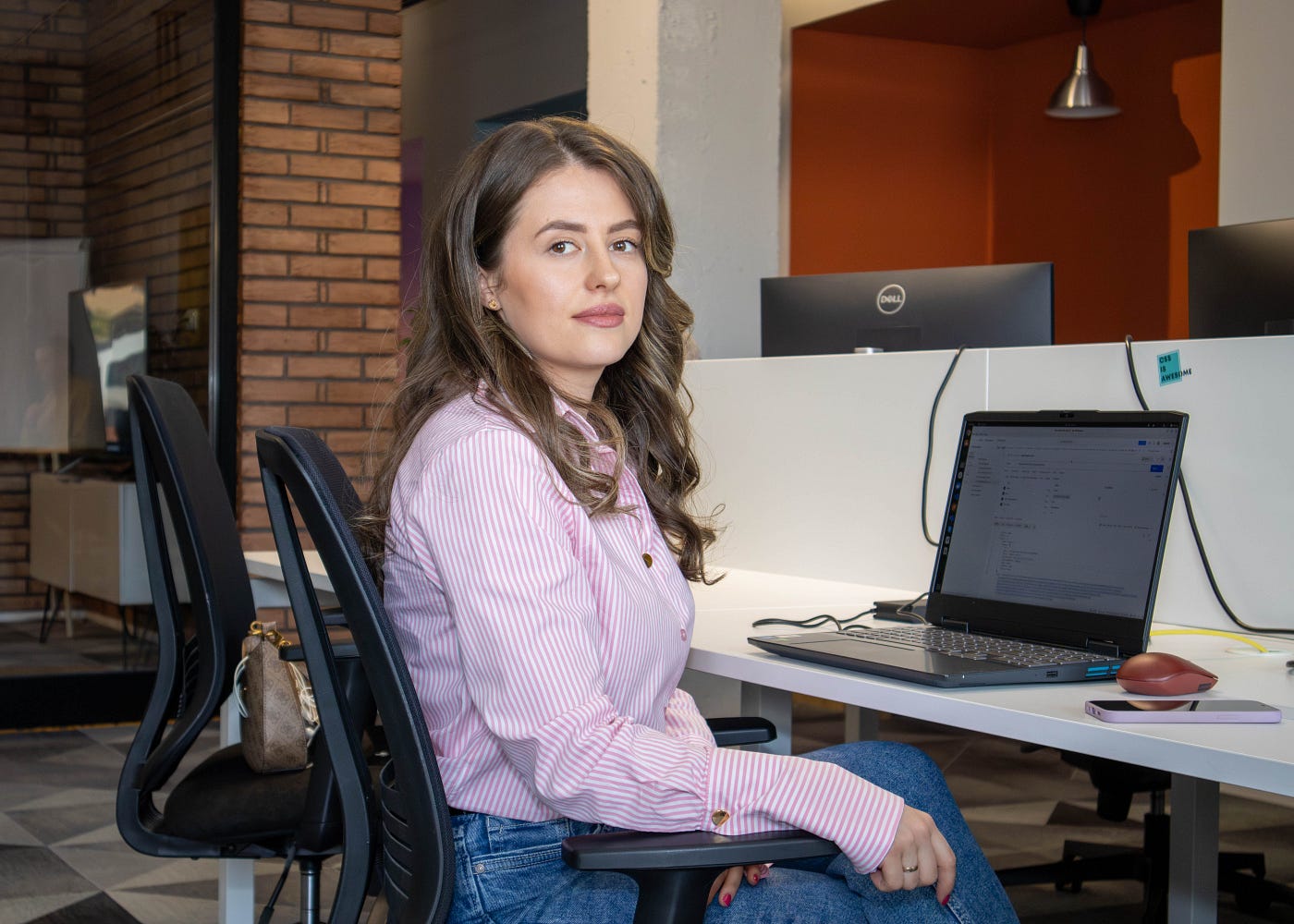 Woman posing by her office desk for a professional photo