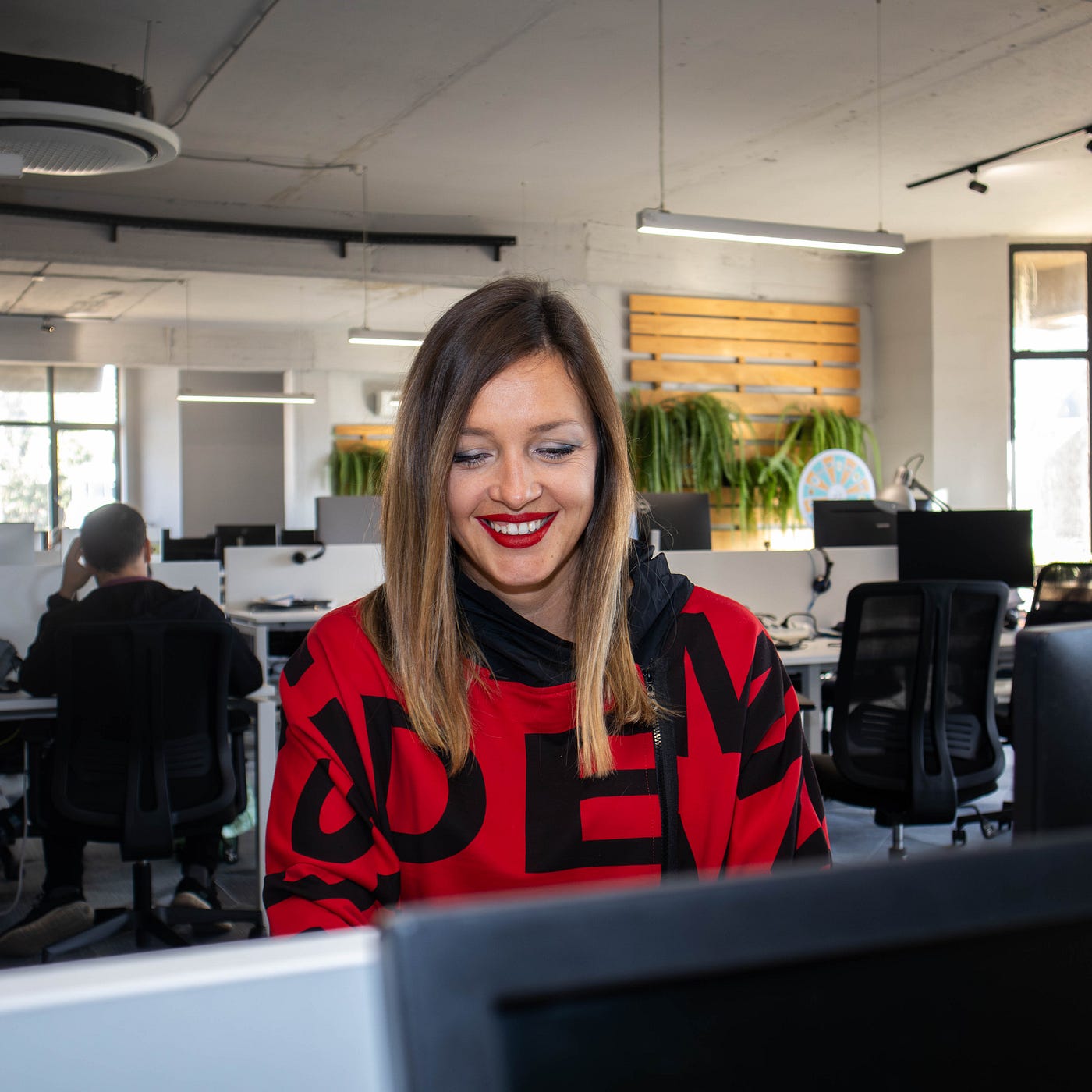 Woman smiling while working on her laptop in the office