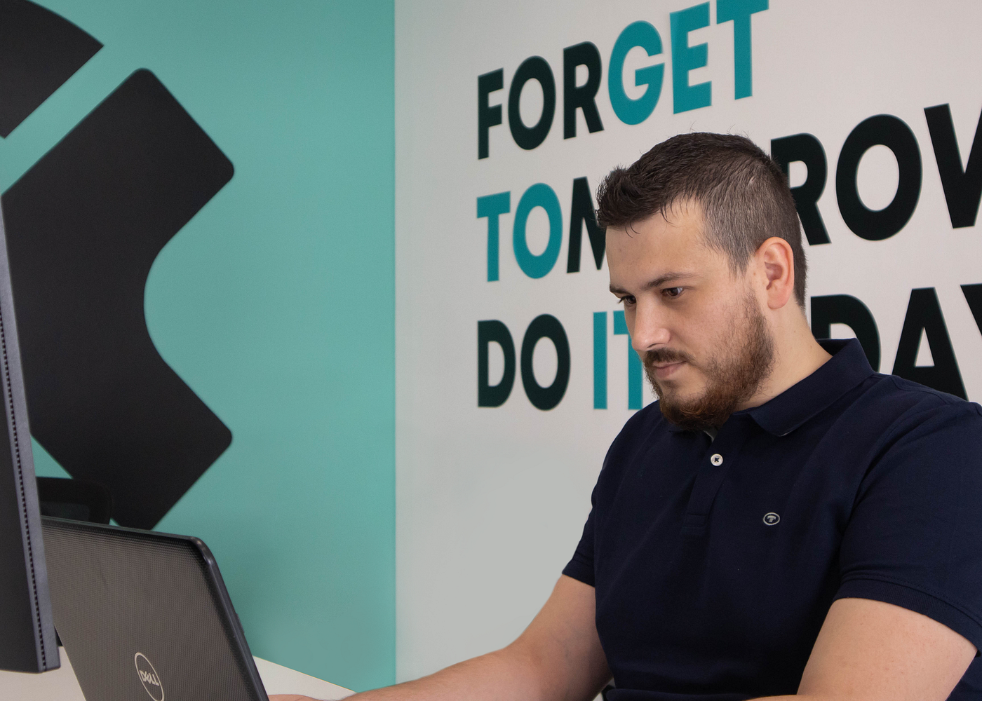 Company intern typing and working on a laptop in the office