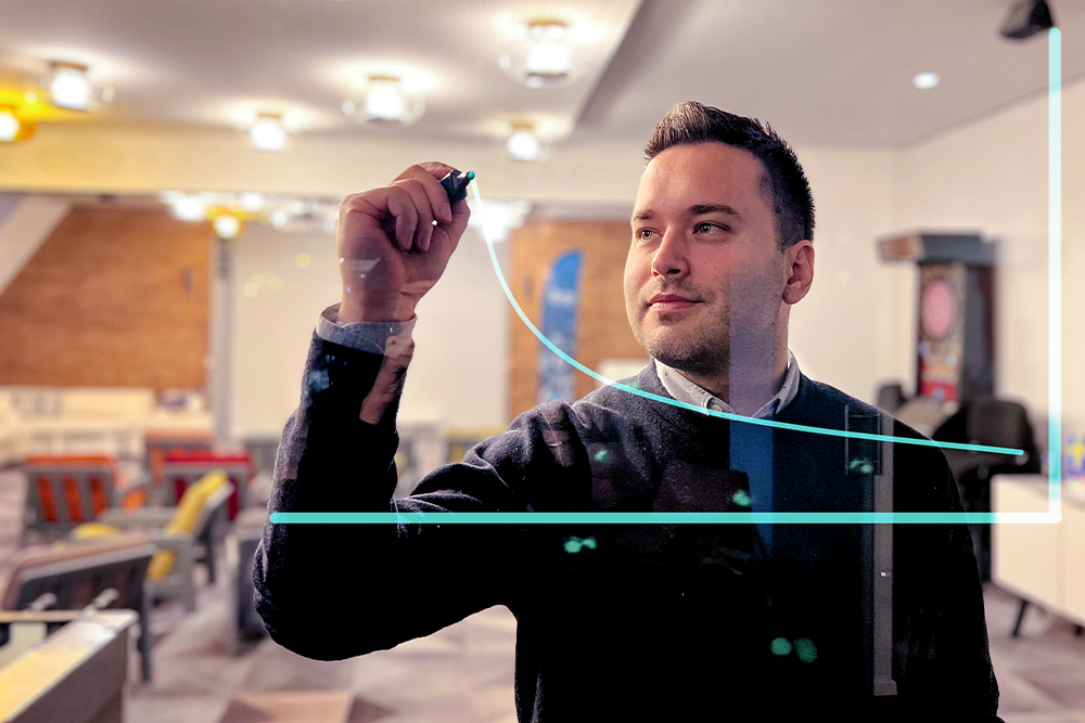 Man drawing on a virtual glass wall in a modern workspace