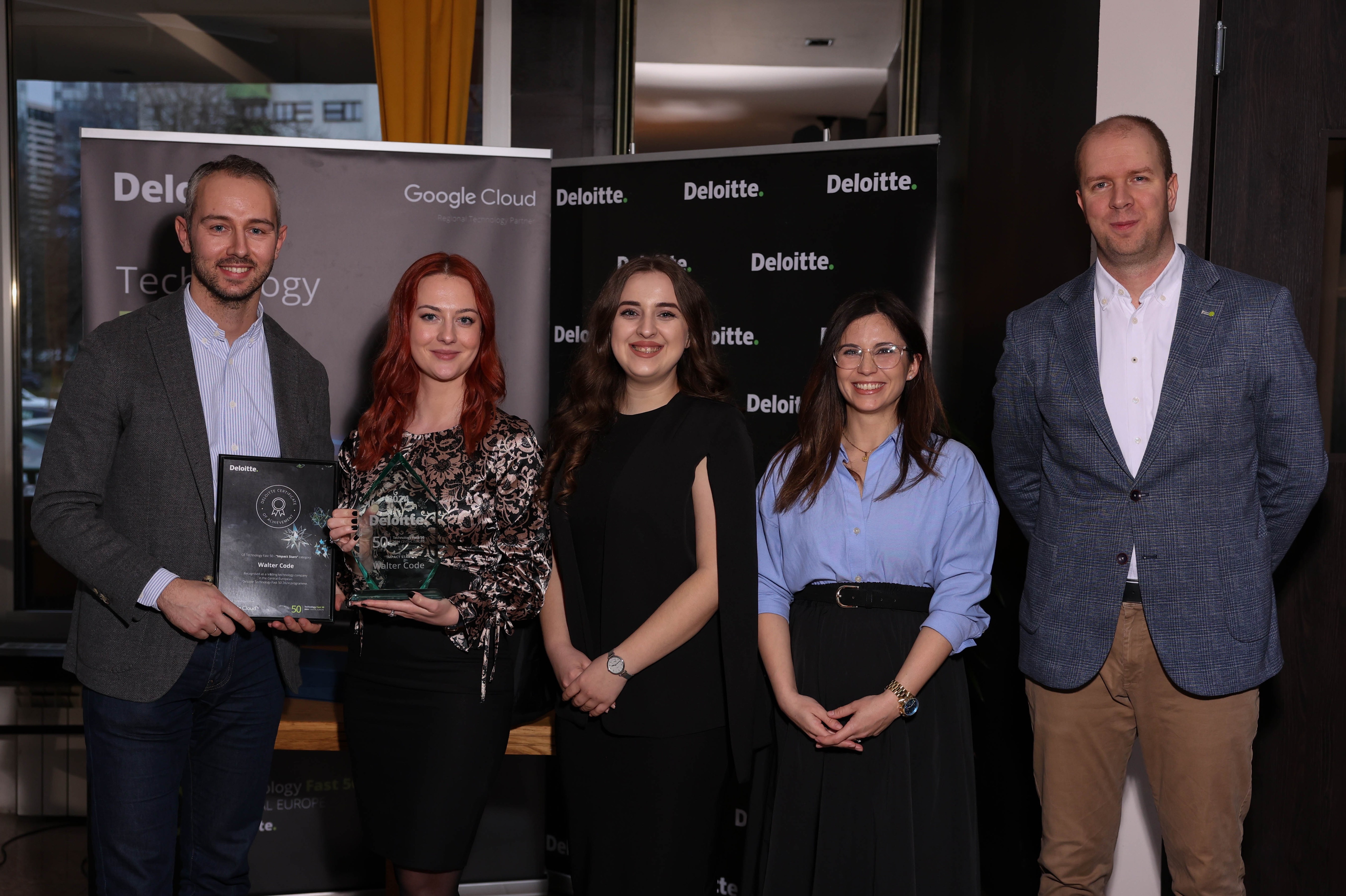 Colleagues celebrating while taking a photo with an award