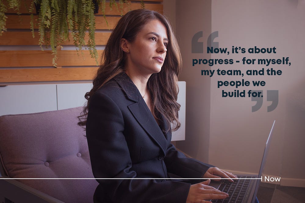 Woman posing with laptop in a modern office setting