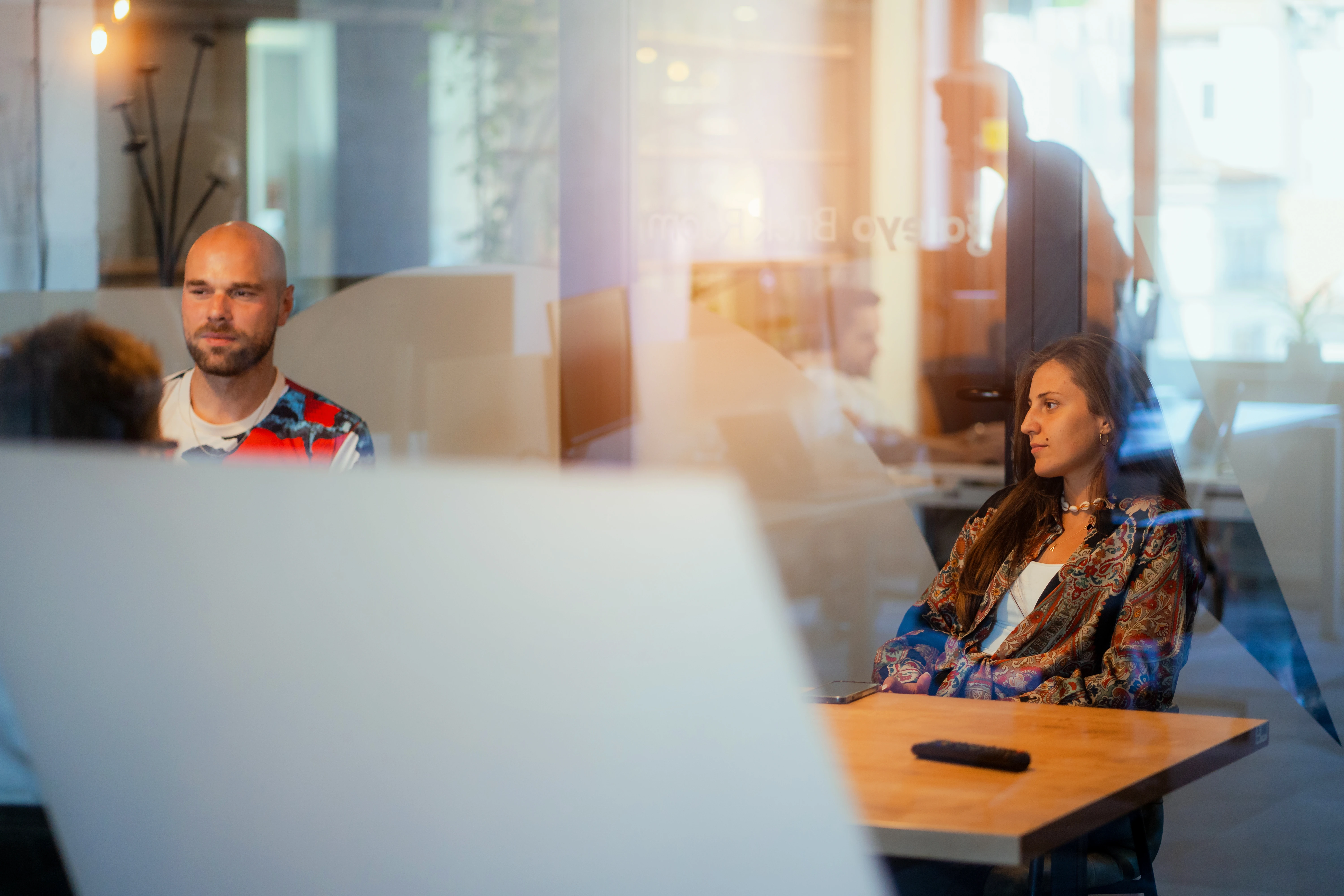 Galeyo team members in a relaxed discussion setting inside a modern glass meeting room