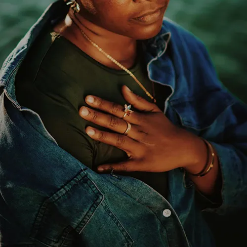 Frau legt ihre Hand auf die Brust. Innere Ruhe und Klarheit