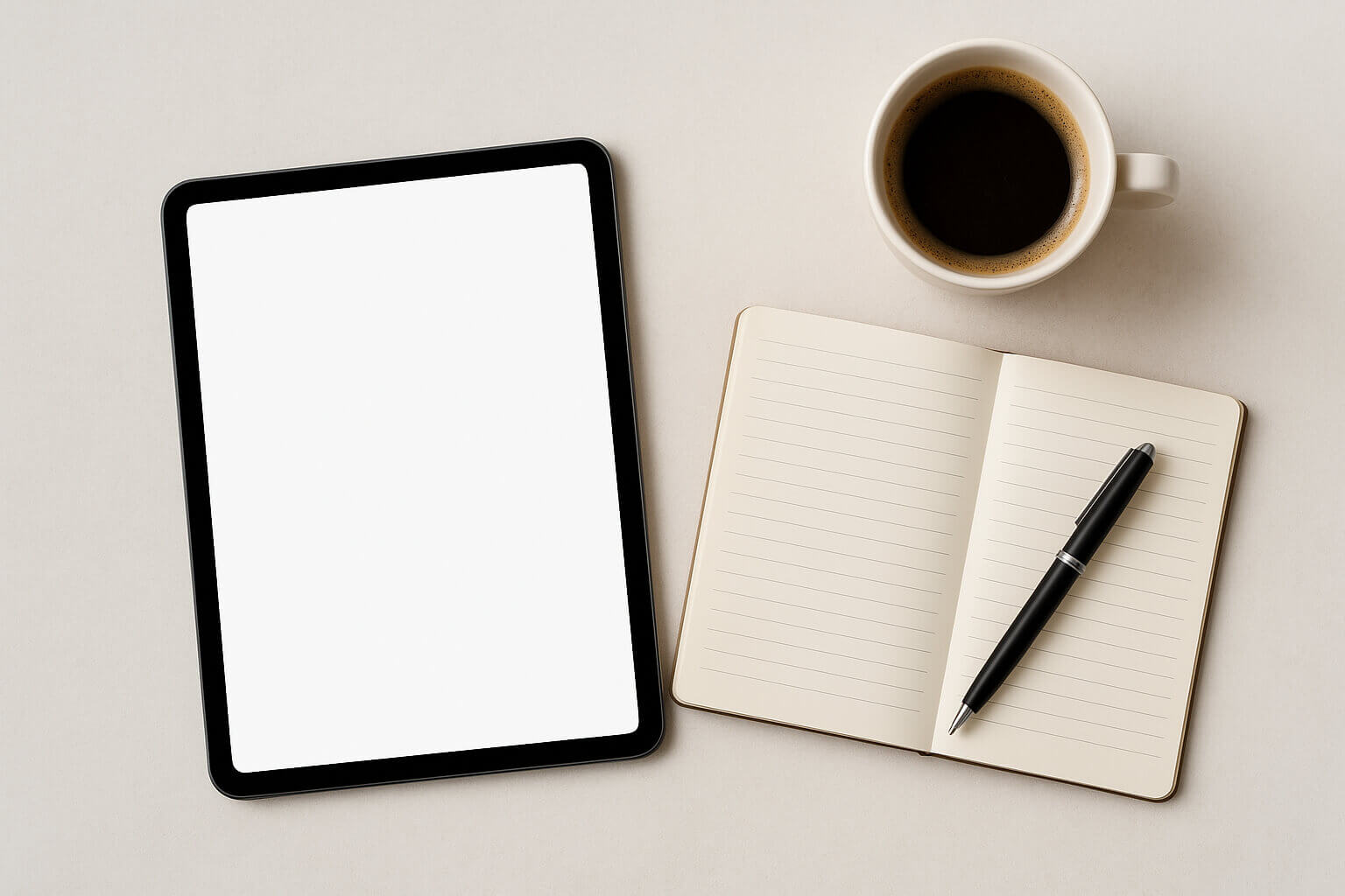 A tablet with a blank screen, an open lined notebook with a pen, and a cup of black coffee on a light surface.