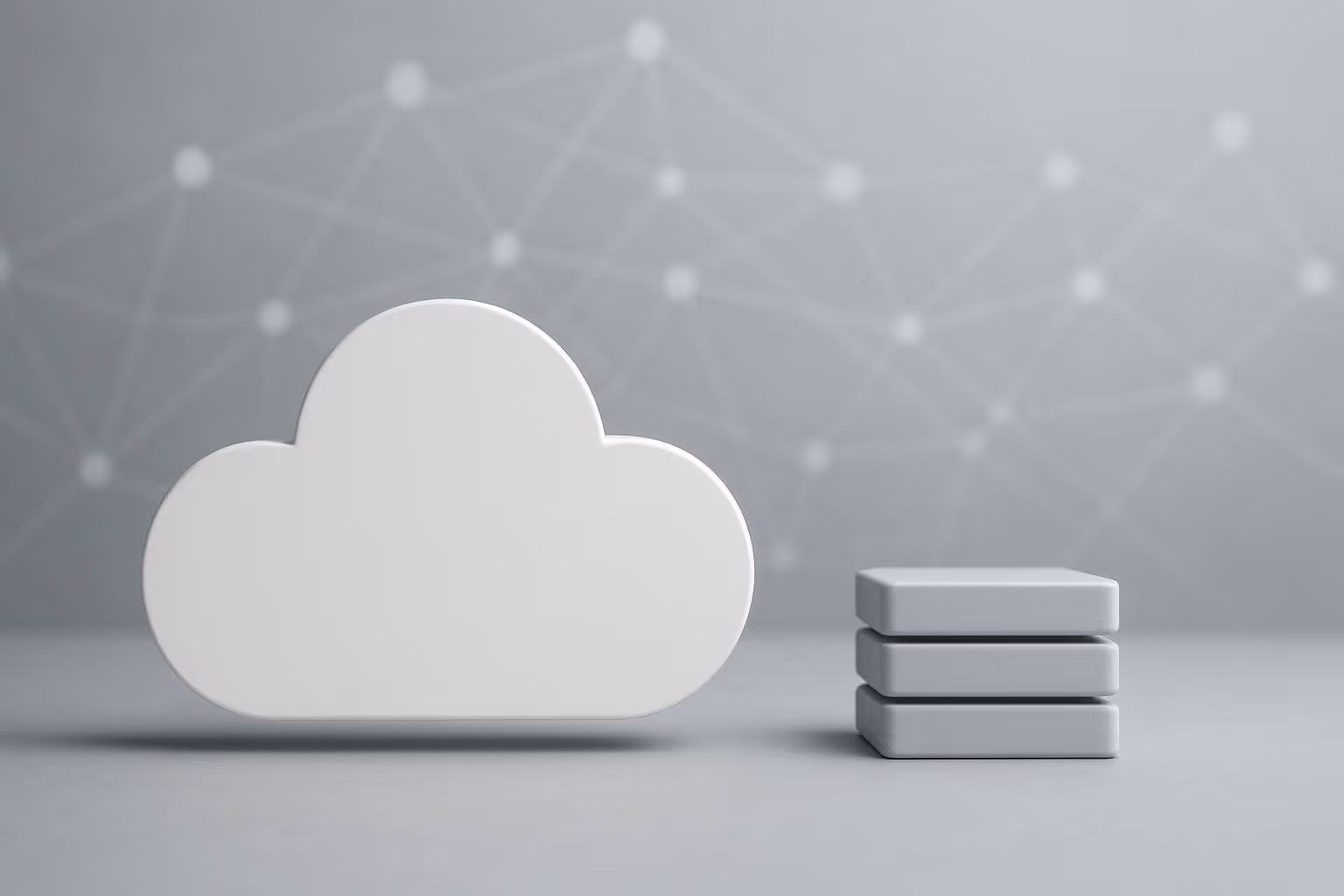 A large white cloud shape stands next to three stacked gray rectangular blocks on a gray surface.