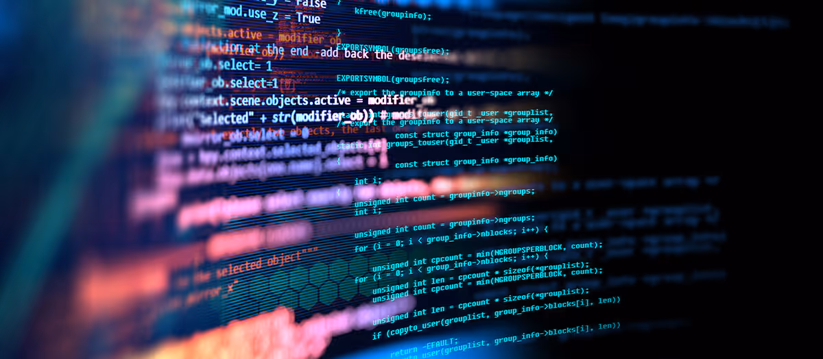 Lines of multicolored computer code are displayed on a dark screen with some text in focus and some blurred.