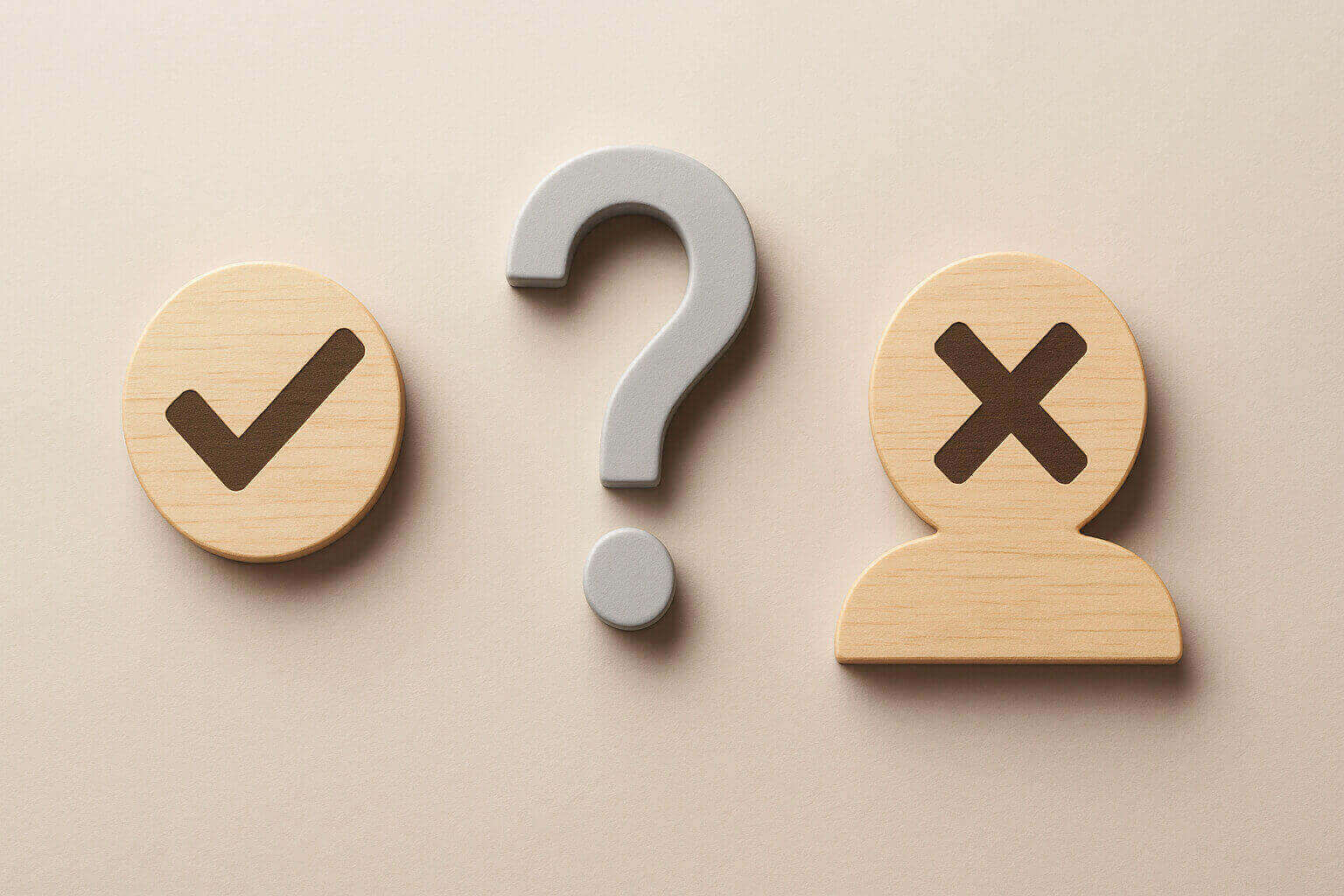A wooden circle with a check mark, a gray question mark, and a wooden figure with an X symbol.