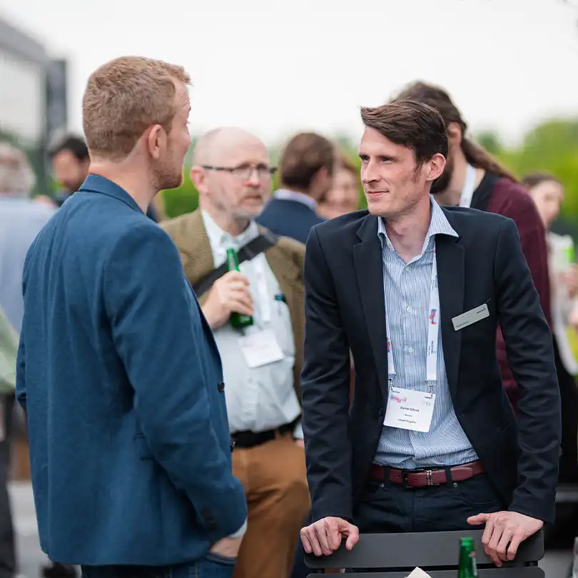 Merford employees networking and exchanging ideas during a professional outdoor event.