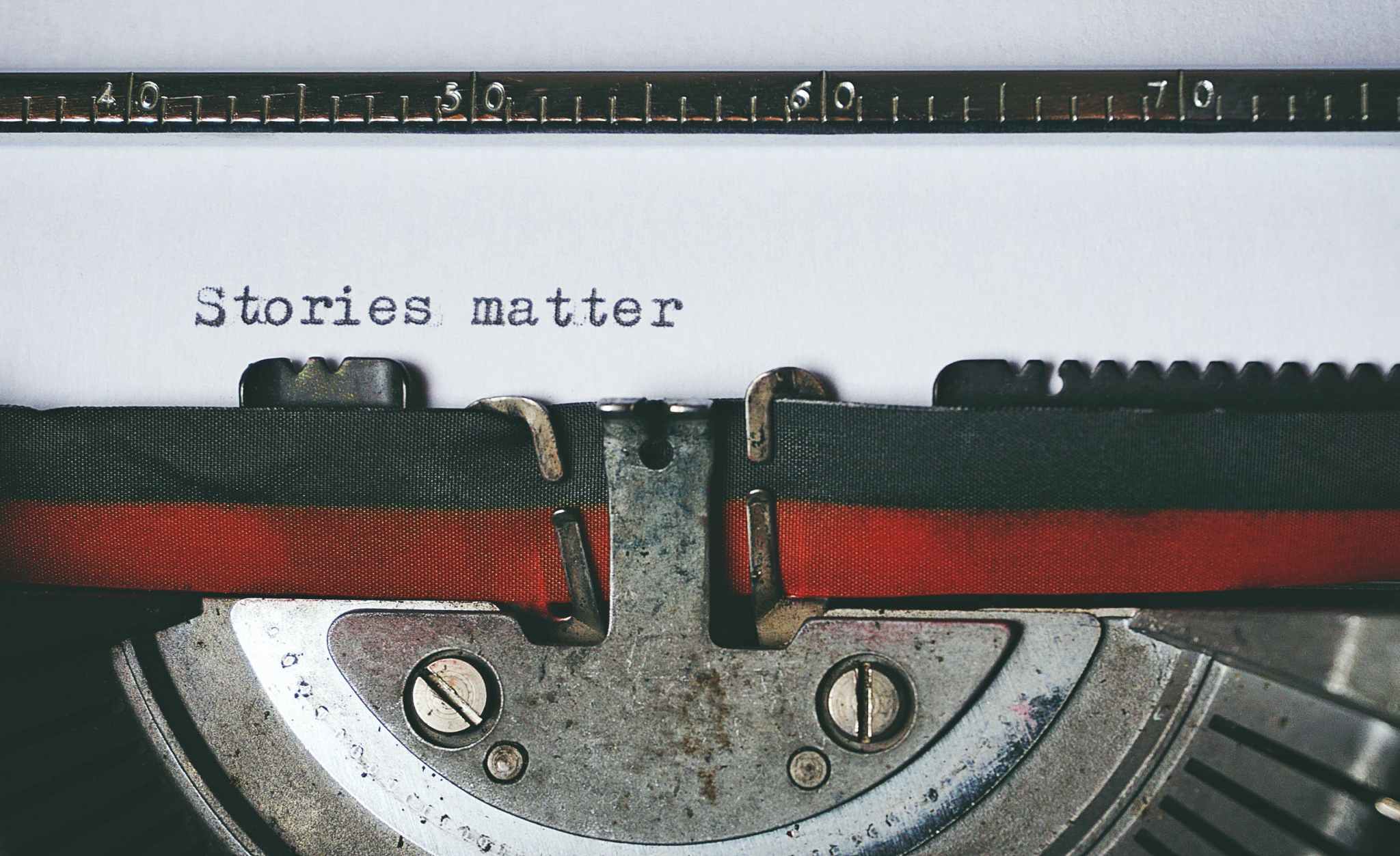 Close-up of a typewriter with the text 'Stories matter' on the paper