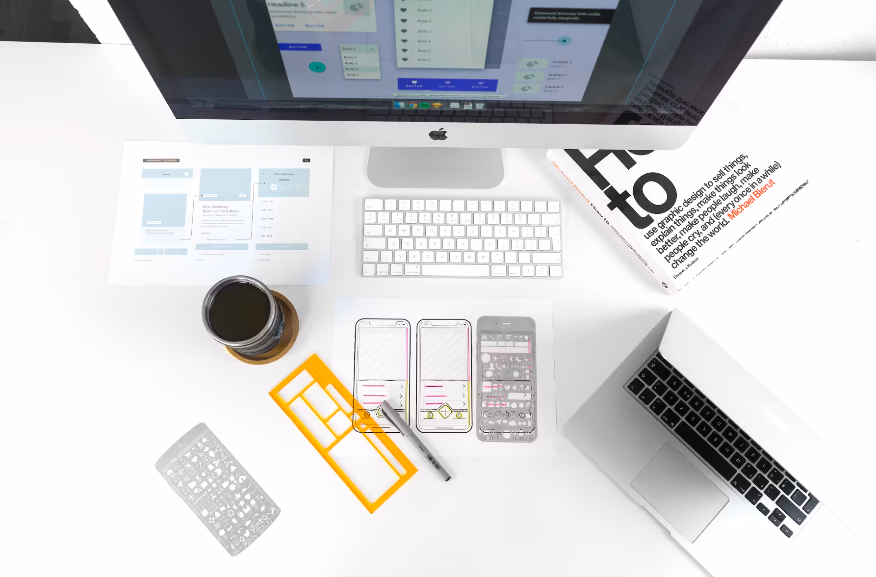 Computer desk with iMac, keyboard, mouse, coffee mug, smartphone, and documents