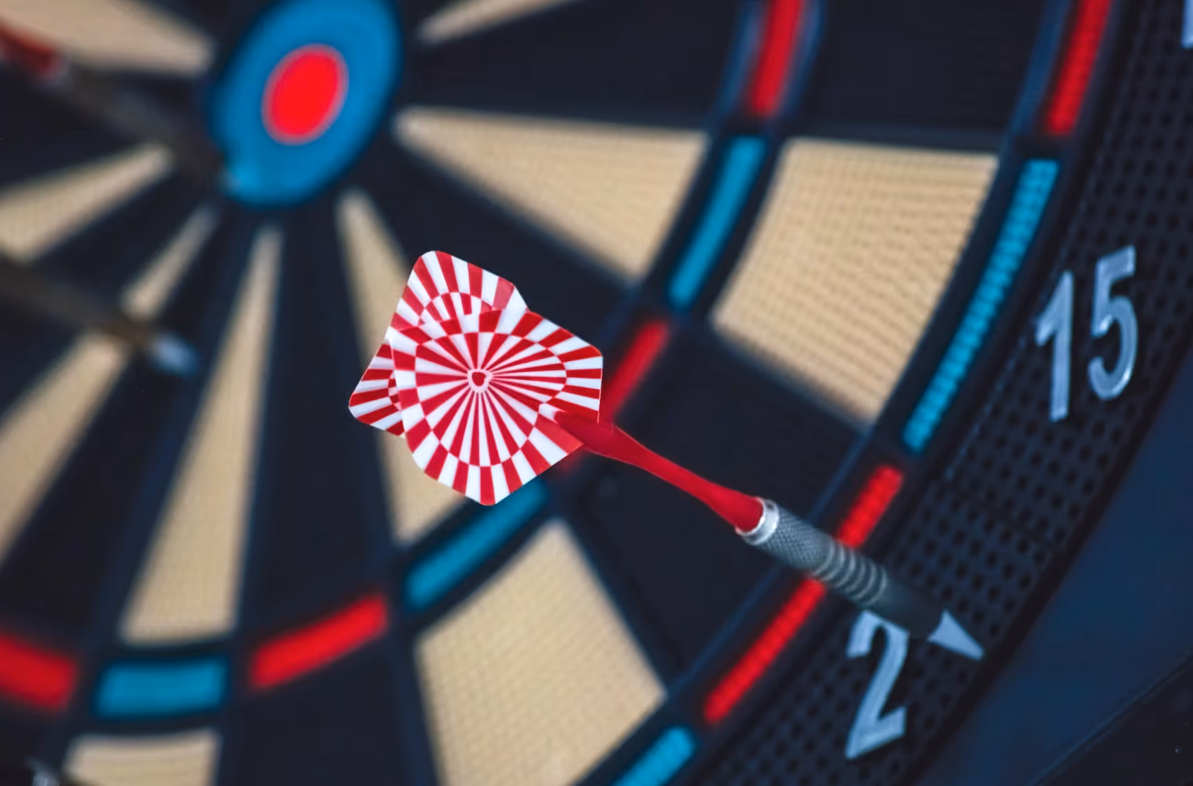 Dart hitting bullseye on dartboard close-up