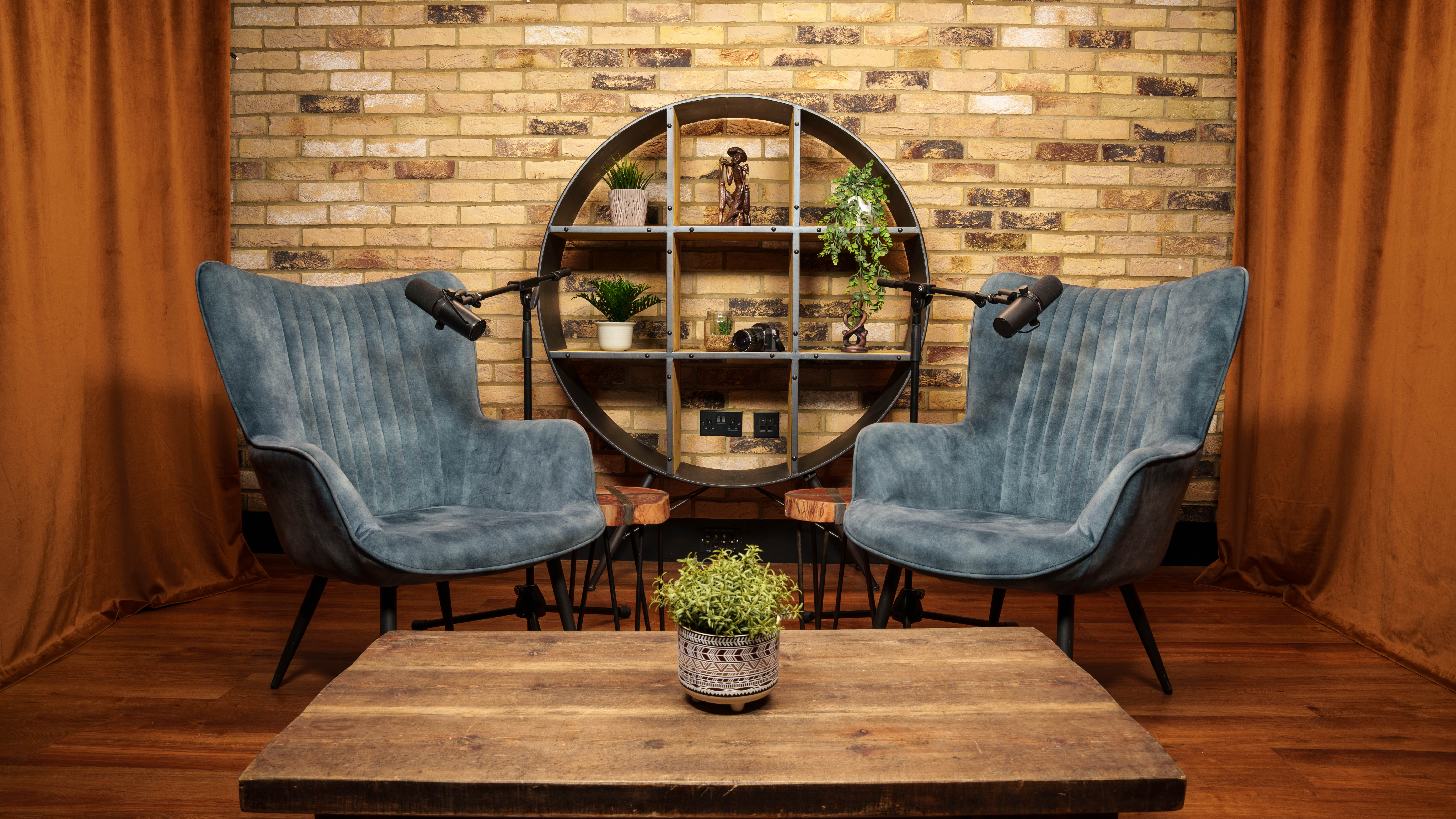 The Founder set, blue armchairs with brick backdrop