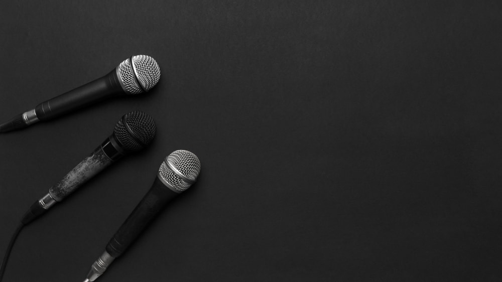 Trio of microphones laying on a black table
