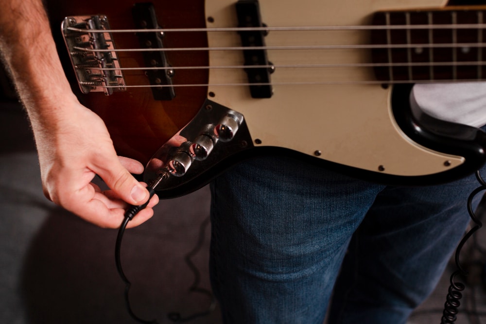 Man plugging a cable into his guitar