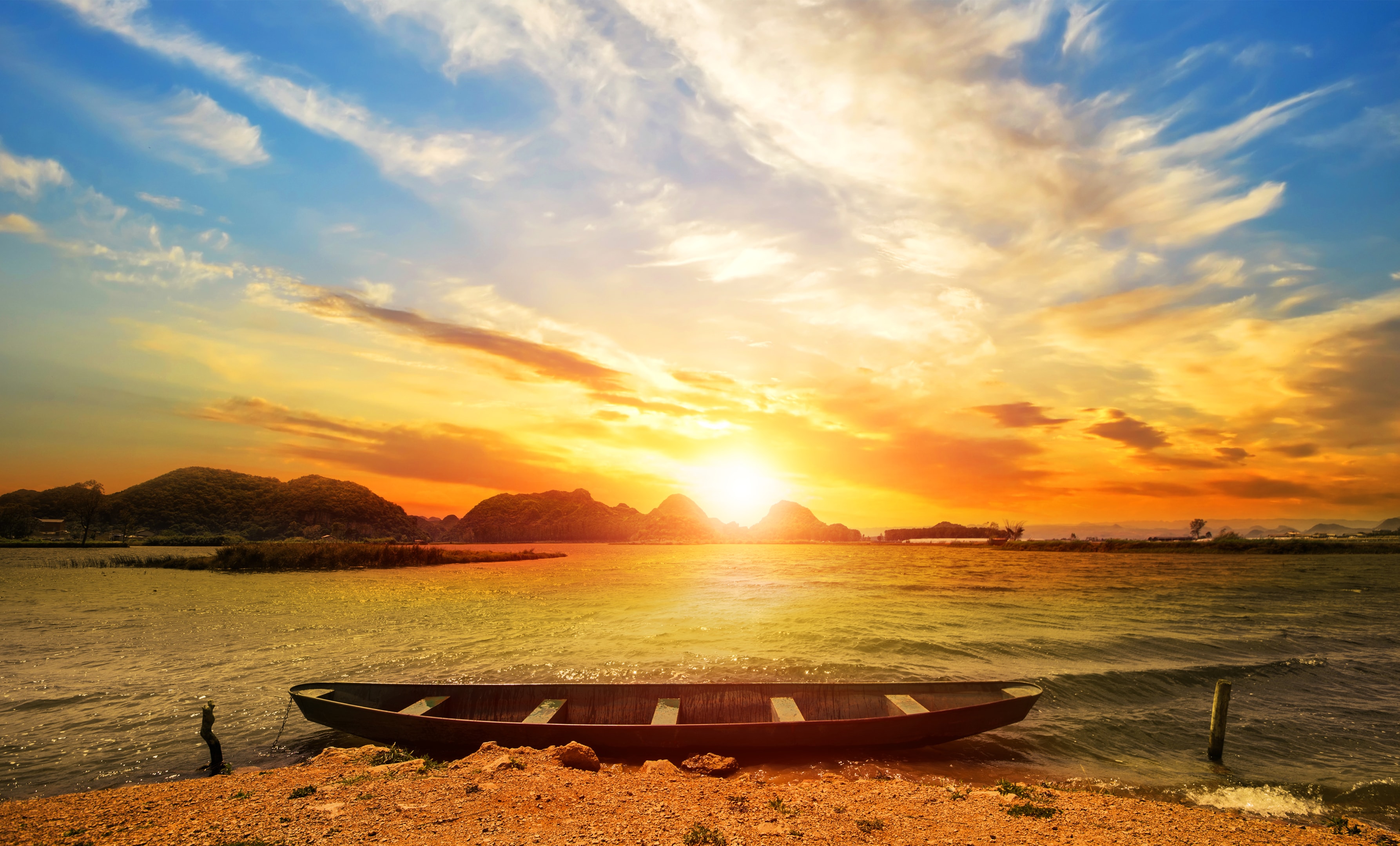 empty rowing boat on shore sunset